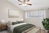Elegant bedroom featuring plush bedding, stylish decor, and ample natural light through large windows.