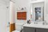 Elegant bathroom featuring a modern white countertop, soft beige shower curtain, and stylish decor, creating a serene and inviting space.