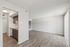 Modern open-plan apartment featuring sleek kitchen cabinetry, spacious living area, and elegant wood-style flooring.