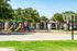 Vibrant apartment community with playground and basketball court, surrounded by lush greenery and modern residential buildings.