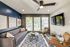 Chic and modern living room with a plush gray sofa, stylish decor, and large windows offering natural light and scenic views.