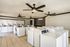 Modern laundry room featuring multiple washing machines and dryers, sleek ceiling fans, and bright lighting for a convenient and comfortable laundry experience.