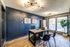 Modern office space with stylish wooden desk, sleek black chairs, and large windows allowing natural light to fill the room. Contemporary lighting and decor add an elegant touch.