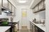 Modern apartment kitchen with sleek cabinetry, stainless steel appliances, and elegant decor, featuring bright natural light and stylish countertops.