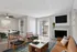 Inviting living room with stylish decor, cozy fireplace, and abundant natural light from large windows.