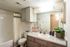 Chic bathroom with modern lighting, stylish vanity, and lush plant accents, perfect for a refreshing start to your day.