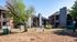 Charming apartment complex with brick and modern accents, featuring lush greenery and a cozy outdoor seating area.