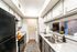 Contemporary kitchen with sleek black and white cabinetry, stainless steel appliances, and elegant countertops complemented by modern decor.