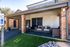 Inviting apartment entrance with covered porch, cozy seating, and vibrant planters, highlighting accessibility and comfort.