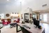 Contemporary open-concept living area with stylish decor featuring vibrant red chairs, sleek work desk, and modern lighting accents.