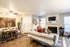 Charming living room with a cozy fireplace, chic sectional sofa, and elegant dining area, illuminated by natural light and stylish decor accents.