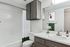 Modern bathroom with elegant dark cabinetry, sleek white countertop, and stylish decor, featuring a full bathtub and large mirror.