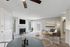 Charming living room with cozy fireplace, modern decor, and large windows offering abundant natural light.