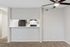 Modern apartment with neutral tones featuring an open breakfast bar and sleek ceiling fan.