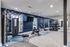 Modern apartment gym with state-of-the-art equipment, including weight bench, exercise bike, and dumbbells, set against stylish blue accent walls.