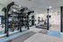 Modern fitness center with state-of-the-art equipment, including kettlebells, punching bags, treadmills, and mirrored walls for optimal workouts.