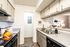 Modern kitchen with sleek countertops, dual sink, and cozy lighting, providing a warm and inviting ambiance.