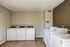 Bright and modern laundry room equipped with multiple washers and dryers, perfect for convenient and efficient living.