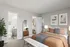 Cozy bedroom with modern decor, featuring a comfortable bed, elegant artwork, a large mirror, lush indoor plant, and an ensuite bathroom.