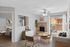 Inviting living room with modern decor, featuring a cozy brick fireplace, stylish furniture, and large windows leading to a balcony, creating a warm and open ambiance.