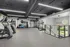 Bright, modern fitness center with state-of-the-art cardio equipment, TRX station, and exercise ball rack offering a refreshing workout space with natural light.