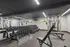 Modern fitness center with mirrored walls, free weights, and versatile workout bench.