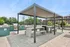 Chic outdoor patio with modern grill and inviting seating area under a stylish pergola, perfect for entertaining in beautifully landscaped surroundings.