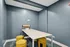 Inviting creative workspace with sleek blue walls, vibrant yellow stools, and a minimalist white table, perfect for inspirational brainstorming.