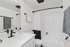 Elegant bathroom with modern fixtures, featuring a sleek vanity, a spacious mirror, and a stylish shower curtain against clean white tiles.