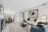 Inviting open-concept living room with modern decor, cozy fireplace, and elegant dining area, bathed in natural light.