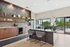 Modern office space featuring a stylish open-plan design with wooden cabinetry, elegant shelving, and natural light overlooking a lush outdoor view.