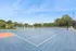 Inviting outdoor sports court surrounded by lush greenery, perfect for tennis enthusiasts seeking recreational activities.