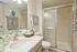 Modern bathroom with sleek glass shower, elegant vanity, and stylish decorative towels.