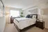 Elegant bedroom with plush carpeting, cozy bed with decorative pillows, and soft natural lighting creating a serene ambiance.