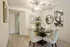 Elegant dining area with modern decor, featuring a stylish round table, plush cream chairs, and chic wall art in a bright, inviting space.