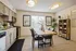Inviting kitchen and dining area with modern cabinets, stainless steel appliances, and a rustic wooden dining table surrounded by elegant chairs. Natural light flows through large windows, complemented by decorative plants and chic wall art.
