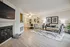 Elegant living room with modern decor, featuring a cozy fireplace, sleek furniture, and stylish artwork. Inviting space with ample natural light and a touch of greenery for a fresh ambiance.