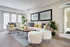 Bright and stylish living room with plush white sofas, elegant decor, and sunlit windows for a modern, cozy vibe.
