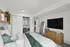 Chic bedroom with a cozy bed, open closet, and stylish decor including a flat-screen TV and full-length mirror.