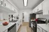 Sleek modern kitchen featuring stainless steel appliances, elegant white cabinetry, and a spacious countertop perfect for culinary creations.