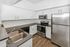 Modern kitchen with sleek stainless steel appliances, elegant dark granite countertops, and crisp white cabinetry.