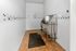 Spacious pet grooming room with playful paw print decor and a stainless steel washing station.