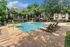 Lush courtyard view featuring a stunning outdoor pool surrounded by elegant lounge chairs and beautiful landscaping, perfect for relaxation.