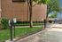 Eco-friendly apartment complex with electric vehicle charging stations, inviting lush greenery and modern convenience.