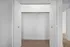 Spacious walk-in closet with white doors and plush carpet, perfect for ample storage and organization.