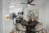 Modern kitchen and dining area featuring sleek appliances, cozy seating, and elegant decor with a vibrant abstract painting.