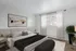 Bright and elegant bedroom featuring a plush bed, abstract art, and large window with sheer curtains.