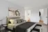 Elegant bedroom with modern decor, featuring a comfortable bed, stylish artwork, and adjoining bathroom.