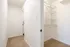 Bright and welcoming hallway with soft carpet leading to a spacious closet featuring modern wire shelving.