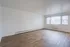 Bright and spacious living area with elegant wood flooring and large windows inviting natural light.